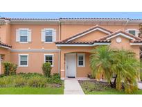 Charming two-story townhouse featuring a red tile roof and a well-maintained landscaped front yard at 2634 Corvette Ln, Kissimmee, FL 34746