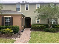 Charming two-story townhome with manicured lawn, walkway, and neat shrubbery around the building at 2894 Tanzanite Ter, Kissimmee, FL 34758