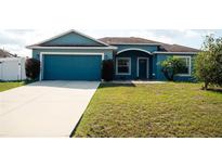 Charming blue single Gathering home with a two car garage, and manicured front lawn at 318 Elderberry Ct, Kissimmee, FL 34759