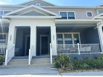 Charming townhome featuring a covered front porch and white railing, perfect for enjoying the outdoors at 452 Diamond Dove Cv, Winter Springs, FL 32708