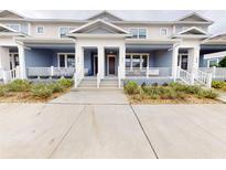 Charming townhome featuring a covered front porch with white railings and neatly landscaped surroundings at 452 Diamond Dove Cv, Winter Springs, FL 32708