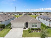 Single-story home showcasing manicured lawn and complemented by a well-kept yard in a suburban neighborhood at 747 Citrus Isle Dr, Davenport, FL 33837