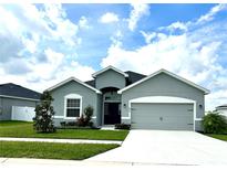 Charming one-story home with a well-manicured lawn and a two-car garage at 870 Galloway St, Lake Alfred, FL 33850