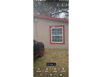 Exterior daytime view of a house with a red trim window and house number above at 888 Berkley Rd, Auburndale, FL 33823