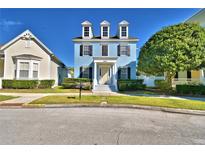 Charming blue two-story home with black shutters and a well-manicured front yard at 1111 Oscar Sq, Celebration, FL 34747