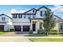 Charming two-story home with manicured landscaping, a two-car garage, and welcoming front entrance at 12761 Westside Village Loop, Windermere, FL 34786