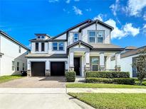 Beautiful two-story home featuring a two car garage, a manicured lawn, and stone veneer accents at 12791 Westside Village Loop, Windermere, FL 34786