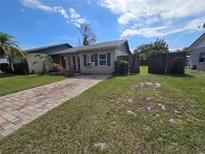 Charming single-story home with a brick driveway and well-maintained lawn at 153 Snapdragon Ct, Kissimmee, FL 34743