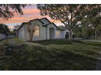 Beautiful single-story home with a manicured lawn and mature trees in a serene suburban setting at 411 Boxwood Dr, Davenport, FL 33837