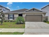 Charming single-story home featuring a two-car garage and well-manicured front yard at 1524 Venice Ln, Davenport, FL 33896