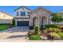Beautiful two-story home with stone accents, arched entryway, and a well-manicured front yard at 1737 Caribbean View Ter, Kissimmee, FL 34747