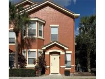 Charming two-story townhome with a welcoming front entrance and lush tropical landscaping at 19934 Villa Isle # 107, Orlando, FL 32821