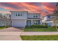Charming two-story home boasts a brick-paved driveway, attached garage, and beautifully landscaped front yard at 3987 Meandering Bay Dr, Apopka, FL 32712
