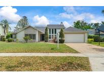 Charming single-Gathering home featuring manicured landscaping and a two-car garage at 5517 Bay Lagoon Cir, Orlando, FL 32819