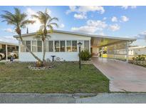 Charming home featuring a front yard with palms, a carport and an enclosed front porch at 6719 Canterbury Ne Dr, Winter Haven, FL 33881