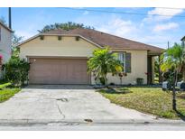Charming single-Gathering home with a tan exterior, attached garage and a well-manicured front yard at 217 Sand Ridge Dr, Davenport, FL 33896