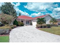 Charming single-story home featuring a well-manicured lawn, paver driveway, and inviting landscaping at 318 Rock Springs Dr, Poinciana, FL 34759