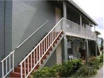 The exterior features stairs with white railings, and a covered porch at 717 Michigan Ct # 2, St Cloud, FL 34769