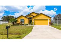 Charming yellow single-Gathering home with a well-maintained lawn and beautiful landscaping at 830 Cabaret Ct, Kissimmee, FL 34759