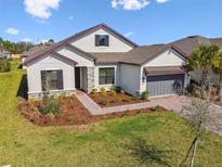 Charming single-Gathering home showcasing stone accents, a well-manicured lawn, and a two-car garage at 937 Walnut Creek Ln, Poinciana, FL 34759