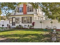 Charming two-story home with a manicured lawn, privacy fence, and quaint outdoor seating area at 1205 Wisconsin Ave, St Cloud, FL 34769