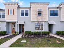 Charming townhouse featuring a modern design with complementary colored stucco and siding, landscaped front yard, and inviting entries at 1800 Tropical Palms Cir, Kissimmee, FL 34747