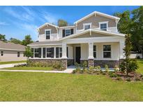 Charming two-story home boasting stone accents, a covered front porch, and a well-manicured lawn at 3725 Deer Ridge Dr, Mount Dora, FL 32757