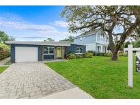 Charming single-story home with a well-manicured lawn, stone accents, and a paved driveway at 4217 Park Lake St, Orlando, FL 32803