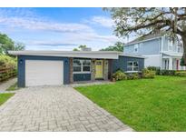 Charming single-story home with a blue exterior, stone accents, a yellow door, and a neatly paved driveway at 4217 Park Lake St, Orlando, FL 32803