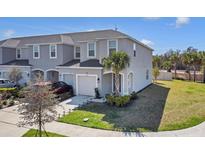 Charming two-story townhouse featuring an attached garage, well-maintained landscaping, and a welcoming front entrance at 4544 Teoli Ct, Kissimmee, FL 34746