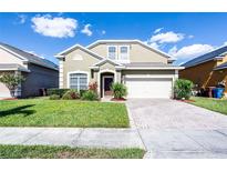 Charming two-story home features a well-manicured lawn and a brick-paved driveway, complete with an attached two-car garage at 509 Cadiz Loop, Davenport, FL 33837