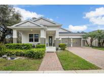Charming single-story home with a well-manicured lawn, a brick walkway, and a three car garage at 11454 Wakeworth St, Orlando, FL 32836
