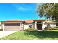 Charming single-story home featuring a well-manicured lawn, stone accents, and a welcoming double-door entryway at 151 Lake Arietta Ct, Auburndale, FL 33823