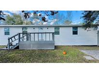Charming single-story home showcasing white siding, a gray porch and stairs, complemented by a well-maintained lawn at 18633 14Th Ave, Orlando, FL 32833