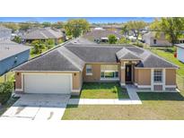 Charming single-story home featuring a two-car garage and well-maintained front yard at 410 Lark Ct, Kissimmee, FL 34759