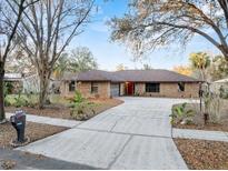 Charming brick home features a long driveway and mature trees in a quiet neighborhood at 4172 Stonehenge Rd, Mulberry, FL 33860