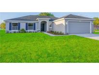 Charming single-story home with a well-maintained lawn, gray exterior and a two-car garage at 421 Britten Dr, Kissimmee, FL 34758