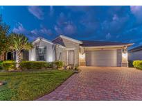 Beautiful single-story home featuring a brick driveway, stone accents, manicured landscaping and a two-car garage at 461 Treviso Dr, Poinciana, FL 34759