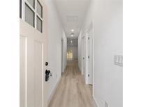 Bright hallway with light wood floors and white walls leads to the rest of the home at 6862 Se 23Rd Ave, Ocala, FL 34480