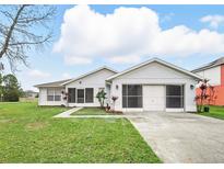 Charming single-story home with a well-manicured lawn and screened garage at 722 Hawk Ln, Kissimmee, FL 34759