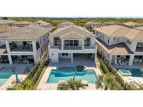 Stunning backyard with a sparkling pool, spa, and covered patio, perfect for outdoor entertaining at 7921 Jacks Club Dr, Kissimmee, FL 34747