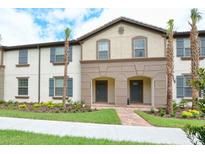 Charming townhome featuring a neutral palette, shutters, manicured lawn, and walkway at 8908 Adriatico Ln, Kissimmee, FL 34747