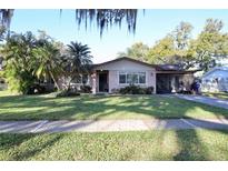Charming single-story home featuring a well-manicured lawn and mature landscaping, offering great curb appeal at 10 Massachusetts Ave, St Cloud, FL 34769