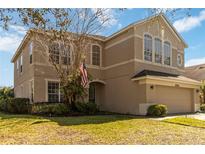 Charming two-story home with a well-manicured lawn and an attached two-car garage at 10368 Stone Glen Dr, Orlando, FL 32825