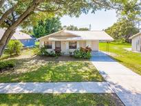 Charming single-story home featuring mature landscaping and a long driveway at 1418 Delaware Ave, St Cloud, FL 34769