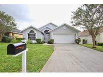 Charming single-story home with a well-manicured lawn, two-car garage, and welcoming front entrance at 153 Laurel Ridge Pass, Davenport, FL 33897