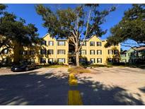 Condo building exterior with parking and trees on a sunny day at 2019 Dixie Belle Dr # 2019L, Orlando, FL 32812