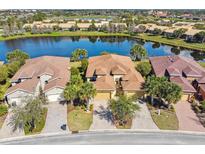 Beautiful aerial view of home, showcasing the lush landscaping and serene lake view at 3390 Fallbrook Dr, Kissimmee, FL 34759