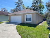 Charming one-story home with a one car garage and well-maintained lawn on a sunny day at 401 Talquin Ct, Orlando, FL 32807