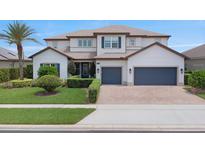 Beautiful two-story home with manicured lawn, brick driveway, and a two-car garage at 4371 Summer Breeze Way, Kissimmee, FL 34744